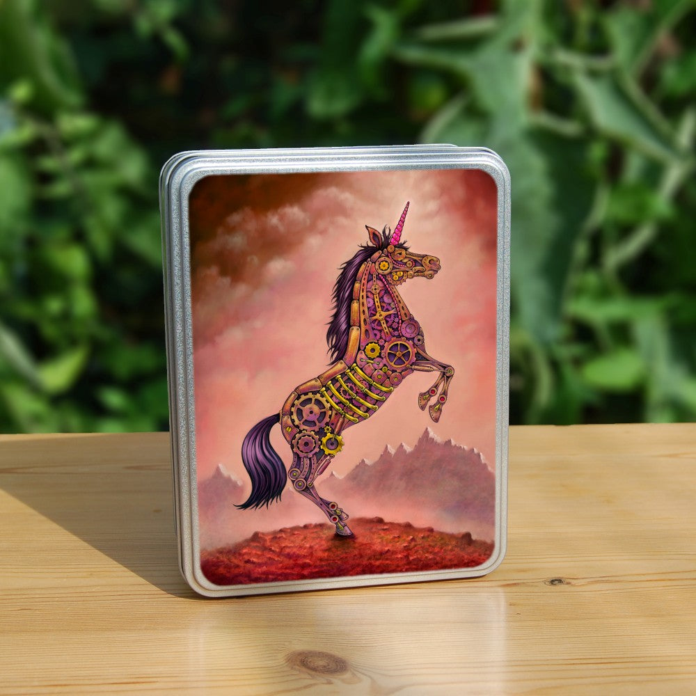 A mechanical unicorn made from cogs, gears and metal plates rears up on its hind legs. The mane and tail are purple, and the horn is pink. Overall colours are pinks, yellows, and browns. The ground beneath and the sky are red, and mountain peaks can be seen in the distance.