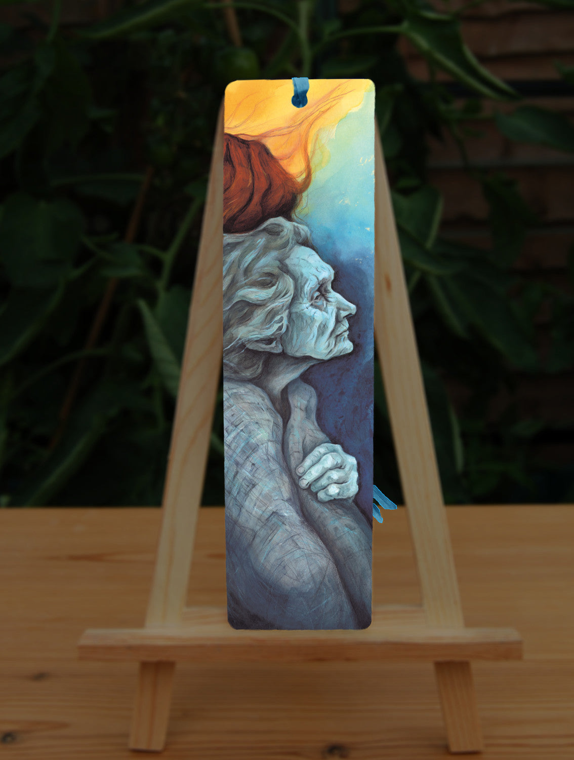 A rectangular bookmark: An elderly woman facing towards the right, coloured in shades of blue and grey.