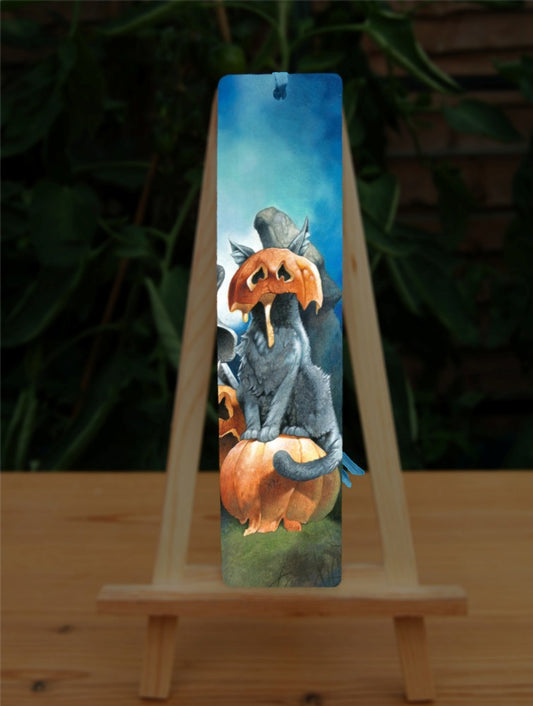 A cat sits on a pumpkin, the top half of another pumpkin squashed over their head, ears protruding out of the top, and pumpkin juice oozing down their front.