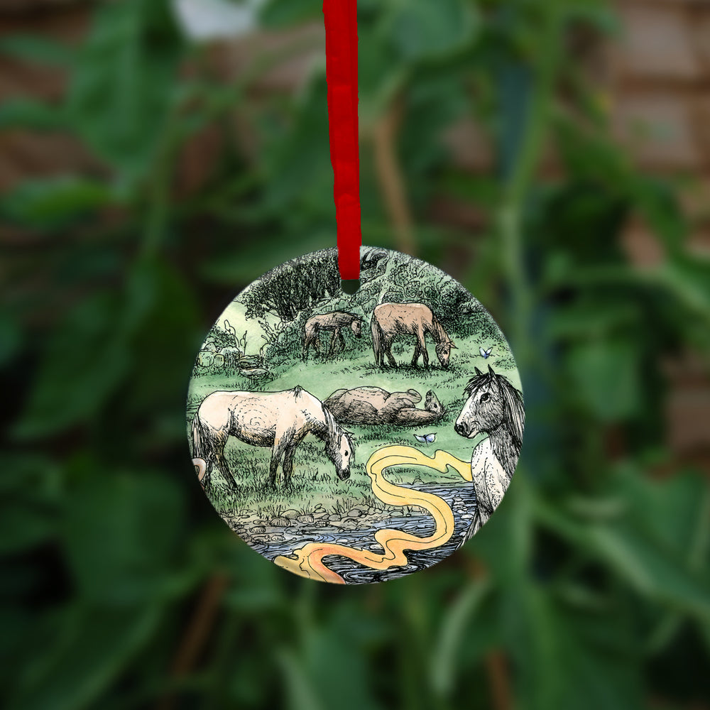 The second side of the ornament. Horses grazing in a field next to a stream.