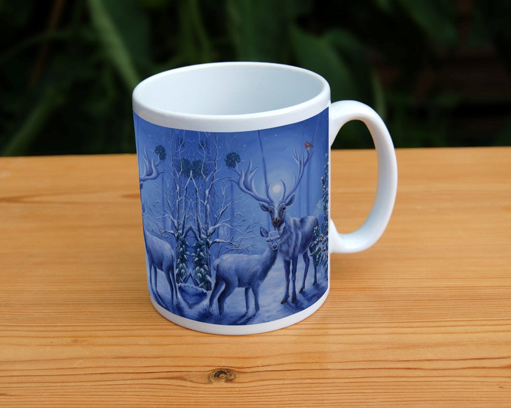 A stag and doe stand facing each other, heads turned towards the viewer. The design is cast in shades of blue. A robin perches on one of the stag's antlers. Snow lies underfoot, and on the branches of the berried holly tree to the right, and bare tree to the left. Pale fairies flit through the branches. Balls of mistletoe sit in the bare tree. A wintery moon rises from between the stag's antlers, and stars can be seen in the sky beyond.