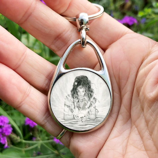 Black and white pencil drawing of a young woman with long dark hair standing waist-deep in water. In her cupped hands she holds a glowing white sphere from which streams of light emerge and flow in all directions. Her face, lowered toward the sphere, is lit by the glow.