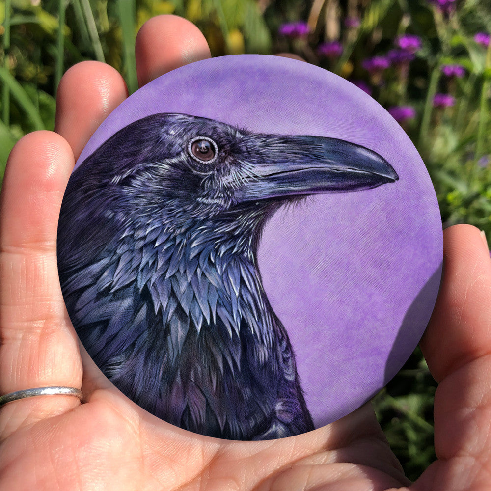 A side view of the head and neck of a raven with lots of feather detail. The raven is coloured black with purple shading, and the background is mottled purple.