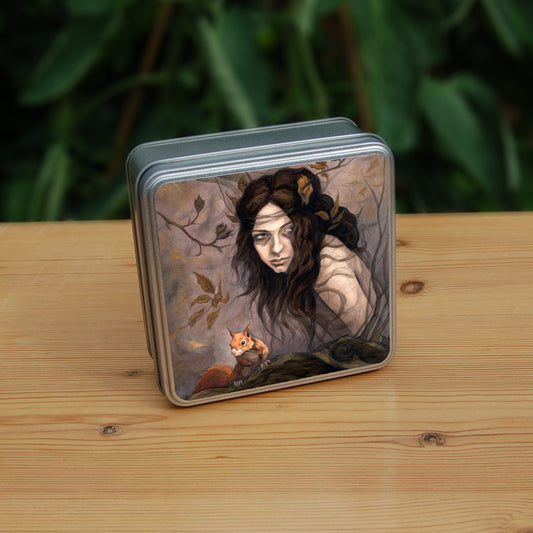 Square tin: The head and body of a young woman appears above a thick tree branch, upon which sits a red squirrel. The woman is turning her head as if to look behind her. She has long brown hair with leaves stuck in it. Autumnal leaves and branches fill the scene. Colours are reds, oranges and browns.