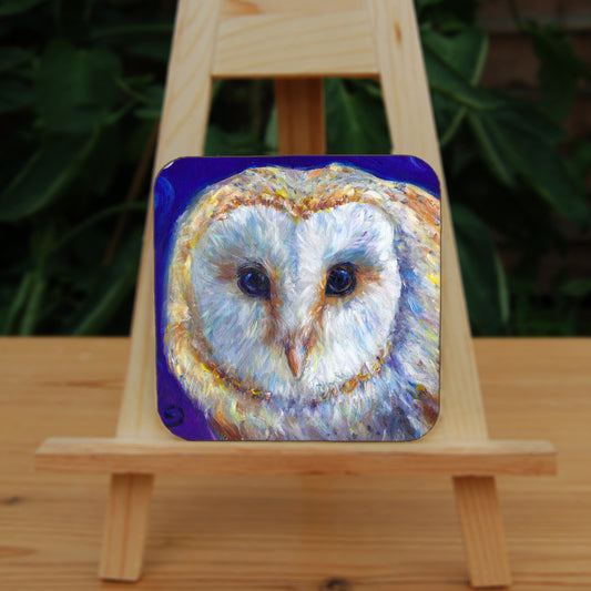 The head of a barn owl, looking directly at the viewer. The background is deep blue.