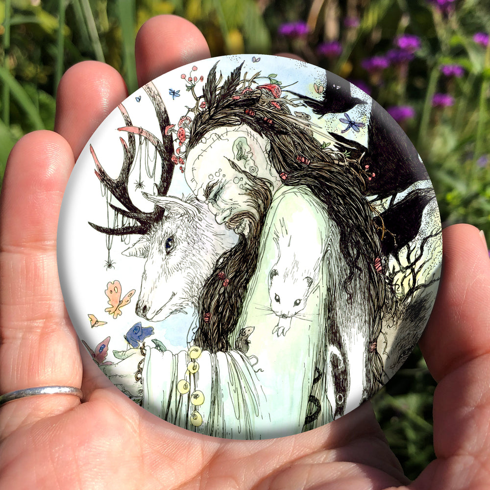 A male figure with long brown hair and beard, both cascading down his body, stands sideways wearing a pale green flowing robe. The side of his head is shaved, and tattooed with a line of characters from the Ogham alphabet. His bound hair contains fungi, a group of feathers, and a mouse. He looks down towards butterflies sitting on his hand. Runes dangle from his arm. A mouse sits in the crook at his elbow. A white stoat appears to form from his shoulder and run down his arm, a badger from his back ...