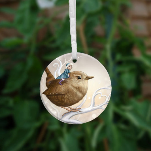 A smiling fairy in a mid-blue coat and hat and purple boots sits on the back of a wren. The wren sits on a white branch. Apart from the fairy, colours are browns and whites.