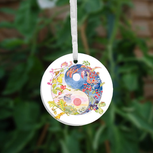 A Yin-Yang shape is surrounded by branches of native trees in autumn colours and some bearing fruit. The left hand half of the shape is filled with a pink/pale orange sky, and a large red sun forms the traditional 'dot' over a grassy hill. Autumn leaves and berries overlay the sky, a jay sings flies over, and fungi sit at the bottom. A moth sits on the outside curve. The right hand half features a dark blue sky with stars, with a white moon forming the 'dot'. Autumn leaves and berries overlay the scene.