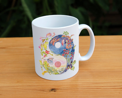 A Yin-Yang shape is surrounded by branches of native trees in autumn colours and some bearing fruit. The left hand half of the shape is filled with a pink/pale orange sky, and a large red sun forms the traditional 'dot' over a grassy hill. Autumn leaves and berries overlay the sky, a jay sings flies over, and fungi sit at the bottom. A moth sits on the outside curve. The right hand half features a dark blue sky with stars, with a white moon forming the 'dot'. Autumn leaves and berries overlay the scene.